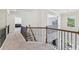 Upper hallway features neutral walls, carpet flooring, and wrought iron railing with a window view at 4775 Columbia St, Cumming, GA 30040