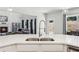 Kitchen featuring a stainless sink, white quartz countertop, and a view into the open-concept living space at 4775 Columbia St, Cumming, GA 30040