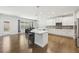 Bright, open kitchen with white cabinets, stainless appliances, and island with barstool seating at 4775 Columbia St, Cumming, GA 30040