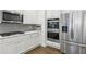 Modern kitchen showcasing stainless steel appliances, sleek white cabinetry, and stylish backsplash at 4775 Columbia St, Cumming, GA 30040