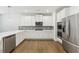 Gourmet kitchen boasts stainless steel appliances, white cabinets, and a large island at 4775 Columbia St, Cumming, GA 30040