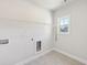Functional laundry room with tile floor, utility sink, washer/dryer hookups, and one window view at 4775 Columbia St, Cumming, GA 30040