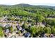 Aerial shot of homes nestled amongst trees, a lake, and mountains in the background at 975 Garden Crossing Ln, Cumming, GA 30040