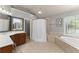 Bright bathroom featuring a soaking tub and neutral tile surround at 975 Garden Crossing Ln, Cumming, GA 30040