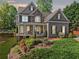 Charming two-story home with a combination of stone and siding and professionally landscaped front yard at 975 Garden Crossing Ln, Cumming, GA 30040