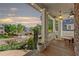 Inviting covered front porch featuring wood flooring, white columns, decorative lighting, and a view of the neighborhood at 975 Garden Crossing Ln, Cumming, GA 30040