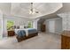 Spacious main bedroom with tray ceilings, neutral paint, and large windows overlooking the yard at 975 Garden Crossing Ln, Cumming, GA 30040