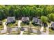 Overhead view of a brick home with a manicured lawn and lush trees and shrubs, surrounded by other residences at 1517 Granby Ln, Locust Grove, GA 30248