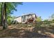Backyard showing a multi-story home with a wooden deck, mature trees, and lawn at 1517 Granby Ln, Locust Grove, GA 30248