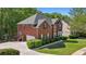 Beautiful red brick home with large driveway, green shutters, and mature trees at 1517 Granby Ln, Locust Grove, GA 30248