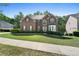 Traditional-style brick home with neatly landscaped front lawn and trimmed hedges on a sunny day at 1517 Granby Ln, Locust Grove, GA 30248