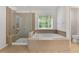 Luxurious bathroom featuring a large tub, separate shower, and tile floors at 1517 Granby Ln, Locust Grove, GA 30248