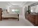 Bright main bedroom featuring a large bed, coffered ceilings, and an ample amount of natural light at 1517 Granby Ln, Locust Grove, GA 30248