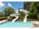 Poolside view of two winding water slides leading into a crystal-clear swimming pool at 1517 Granby Ln, Locust Grove, GA 30248