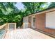 Backyard deck adjacent to a brick home is surrounded by lush, green landscaping at 3207 Canary Ct, Decatur, GA 30032