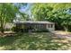 Quaint brick home with mature trees, green lawn and a long driveway at 3207 Canary Ct, Decatur, GA 30032