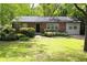 Charming one story brick home with lush landscaping, mature trees, and a well-manicured lawn at 3207 Canary Ct, Decatur, GA 30032