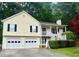 Charming two-story home with a two-car garage, front porch, landscaped yard, and mature trees at 1043 Foxhollow Trl, Canton, GA 30115