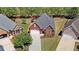 High-angle view showcasing a red brick house, green lawn, and paved driveway in a well-kept neighborhood at 1610 Glenhurst Dr, Snellville, GA 30078