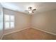 Neutral bedroom with tan carpet, ceiling fan, window with blinds and light-colored walls at 1610 Glenhurst Dr, Snellville, GA 30078