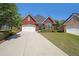 Beautiful brick home featuring a two-car garage, well-kept lawn, and tasteful landscaping details at 1610 Glenhurst Dr, Snellville, GA 30078