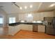 Modern kitchen with white cabinets, stainless steel appliances, granite countertops, and hardwood floors at 1610 Glenhurst Dr, Snellville, GA 30078