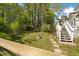 A serene backyard with lush greenery, featuring a well-maintained lawn and a charming stone pathway leading to the stairs at 2441 Mitchell Ne Rd, Marietta, GA 30062
