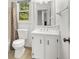 Bathroom features a white vanity with storage and a toilet, complemented by natural light at 2441 Mitchell Ne Rd, Marietta, GA 30062