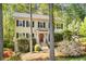Charming home with a vibrant red door, black shutters, mature trees, and a well-manicured lawn at 2441 Mitchell Ne Rd, Marietta, GA 30062