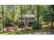 Beautiful home with a manicured lawn, mature trees, a basketball hoop, and a charming red front door at 2441 Mitchell Ne Rd, Marietta, GA 30062