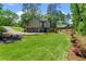 Serene backyard featuring a lush lawn, mature trees, and charming string lights for outdoor gatherings at 3603 Allpoint Dr, Marietta, GA 30062