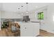 Open kitchen featuring an island with seating, stainless appliances, white cabinets, and hardwood floors at 3603 Allpoint Dr, Marietta, GA 30062