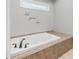 A luxurious soaking tub is tiled with decorative accents at 503 Pinehurst Ln, Woodstock, GA 30188