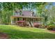 Inviting exterior featuring a charming covered porch, lush landscaping, and well-maintained lawn at 503 Pinehurst Ln, Woodstock, GA 30188