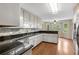 Modern kitchen with granite countertops, white cabinetry, and stainless steel appliances at 503 Pinehurst Ln, Woodstock, GA 30188