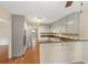A full kitchen view with granite countertops, light cabinets, and an eat-in bar at 503 Pinehurst Ln, Woodstock, GA 30188