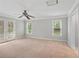 A spacious main bedroom with carpet flooring, ceiling fan, and a door leading to a patio at 503 Pinehurst Ln, Woodstock, GA 30188
