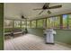 Cozy sunroom with ceiling fans, wood flooring, grill, and views of the green backyard at 503 Pinehurst Ln, Woodstock, GA 30188