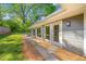 Home featuring a gray wood exterior, surrounded by a vibrant green yard and lush trees at 1153 Chatsworth Dr, Avondale Estates, GA 30002