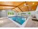 Indoor pool area with striking wood-beam vaulted ceilings, multiple windows, and tiled flooring at 1153 Chatsworth Dr, Avondale Estates, GA 30002