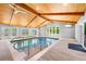 Bright indoor pool features wood-beam vaulted ceilings, recessed lighting, and surrounding windows at 1153 Chatsworth Dr, Avondale Estates, GA 30002