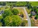Aerial view of property with mature trees, a house, and a paved road nearby at 1312 Harbins Rd, Dacula, GA 30019
