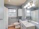 Updated bathroom with gray walls, white fixtures, and large vanity mirror with excellent lighting at 1312 Harbins Rd, Dacula, GA 30019