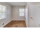 This bright bedroom boasts hardwood floors, neutral paint, and a sunny window at 1312 Harbins Rd, Dacula, GA 30019