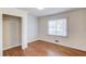 This neutral-painted bedroom has closet with folding doors, hardwood flooring and a window at 1312 Harbins Rd, Dacula, GA 30019