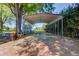 Exterior shot shows a carport with metal beams, a shed and gravel driveway at 1312 Harbins Rd, Dacula, GA 30019