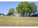 Wide angle shot of an older, single story ranch home with light paint on a large, grassy lot and mature trees at 1312 Harbins Rd, Dacula, GA 30019