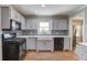 Kitchen featuring gray cabinets, stainless appliances, farm sink and tile backsplash at 1312 Harbins Rd, Dacula, GA 30019