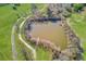 Scenic aerial view of a tranquil pond surrounded by lush greenery and walking paths at 1312 Harbins Rd, Dacula, GA 30019