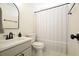 Clean bathroom featuring a light vanity, black fixtures, toilet and neutral shower curtain at 2525 Ashton Dr, Roswell, GA 30076